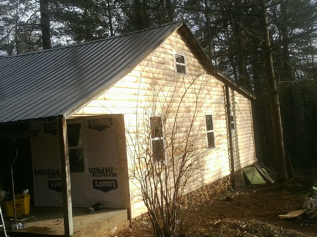 Log siding gable end under a dark metal roof edge in Treynor