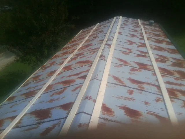 Rusted metal roof panels with new wood purlins before replacement — Storm Damage Roof Repair in Treynor by Roofing Brothers