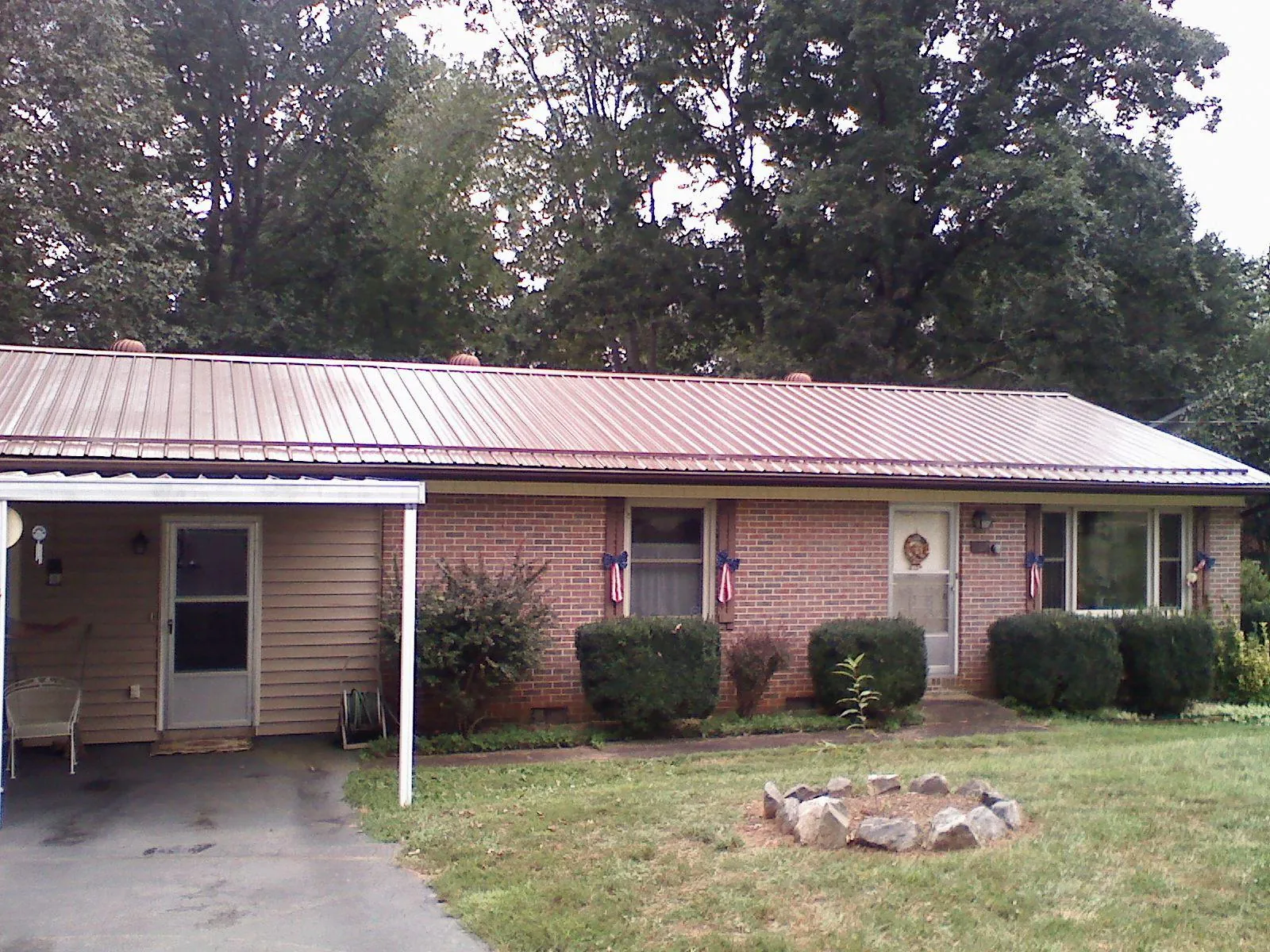 Bronze metal roof and carport on a brick ranch home — Roof Repair work by our crew in Treynor